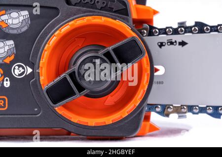 Detail of the mechanism to adjust the chain of an electric chainsaw isolated on white background Stock Photo