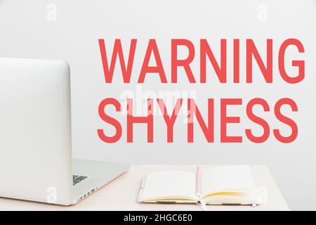 Hand writing sign Warning Shyness. Internet Concept Lack of confidence Not able to speak out or express oneself Tidy Workspace Setup, Writing Desk Stock Photo