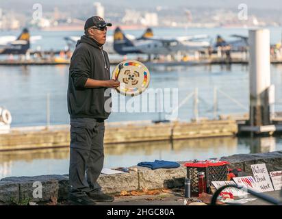 Native amrican man holding and playing their sacred drums outdoors. Stock Photo