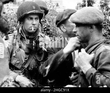 Members of the French Resistance and the US 82nd Airborne division discuss the situation during the Battle of Normandy in 1944. Stock Photo