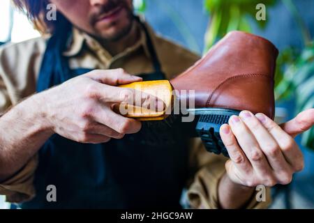 skilled shoemaker make a leather shoes in workshop Stock Photo