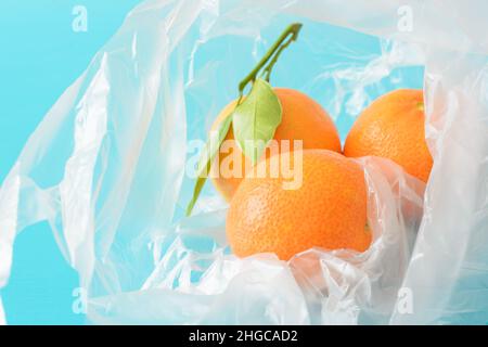 Fresh tangerines with leaves in a plastic bag Stock Photo