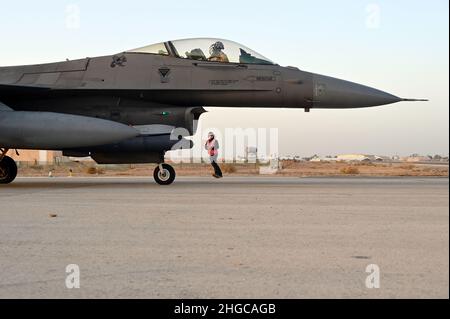 332nd Air Expeditionary Wing Airmen perform a hot-pit maintenance check on a U.S. Air Force F-16 Fighting Falcon aircraft in Southwest Asia Jan. 13, 2022. Hot pit refers to the maintenance, refueling or reloading of munitions immediately after landing while the aircraft keeps an engine running. (U.S. Air Force photo by Tech. Sgt. Lauren M. Snyder) Stock Photo