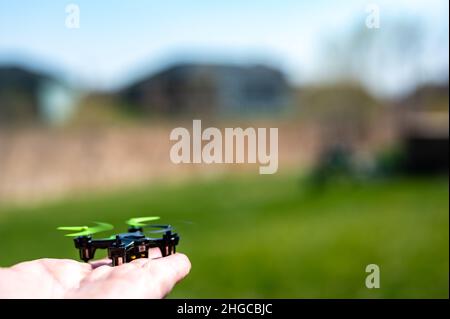 Miniature toy remote controlled drone taking off from a hand Stock Photo