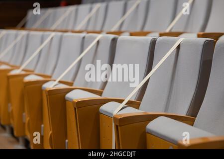 Blocked odd seats in theatre for preventing corona virus covid19 disease. Tape over seats as a barrier for social distancing on events such as theatre Stock Photo