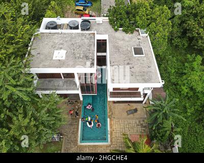 Port Dickson, Malaysia: Nov 19, 2021 - Aerial view of a bungalow with private swimming pool surrounded with trees. Stock Photo