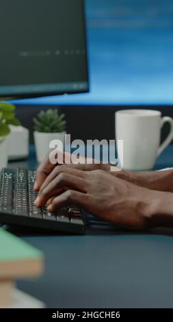 Close up of black hands coding server interface with binary codes on computer. African american coder programming website firewall for protection and software development. Web programmer Stock Photo