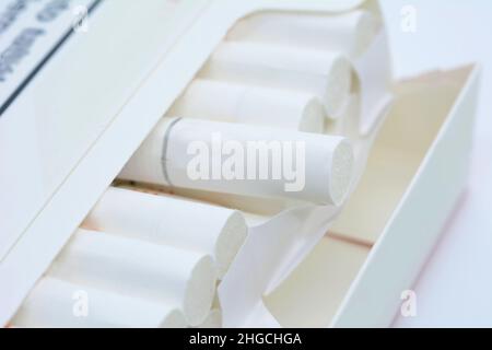 A closeup of open white pack of cigarettes on a white background. Stock Photo