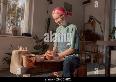 Young potter working with clay in workroom Stock Photo