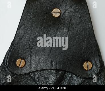 Black leather patch with metal screw isolated on studio background Stock Photo
