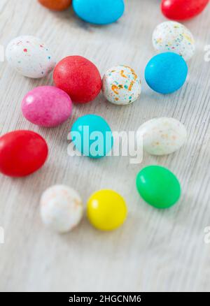 Easter candy eggs on white wooden surface Stock Photo