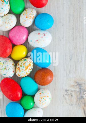 Easter candy eggs on white wooden surface Stock Photo