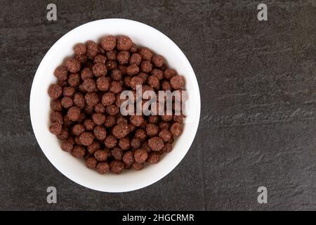 Balls of chocolate flakes on a black stone surface Stock Photo