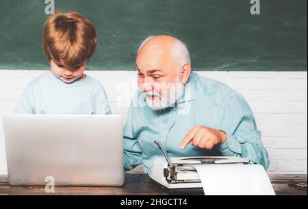Grandfather and grandson. Elementary school kid and teacher with laptop in classroom at school. Thank You Teacher. Tutoring. Stock Photo