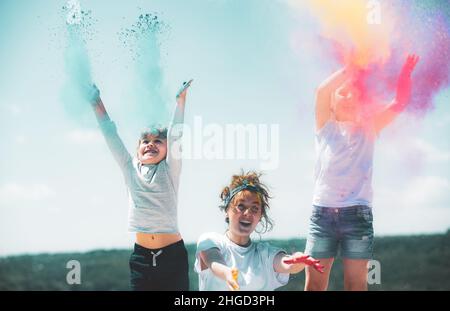 Excited children painted in the colors of Holi festival. Kids splashing colorful paint. Stock Photo