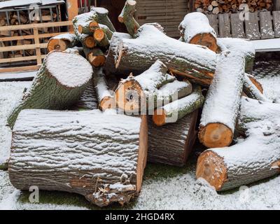 Firewood covered with snow in winter Stock Photo