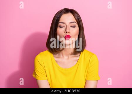 Portrait of attractive sweet tender dreamy girl sending you kiss isolated over pink pastel color background Stock Photo