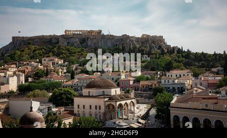 view from a roof top bar over inner city of athens with the acropolis in the background.