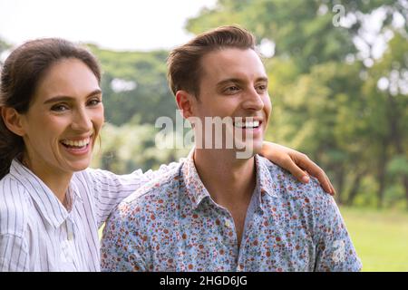 young couple man and woman falling in love and dating in park. wife hugging and enjoying with smiling of her husband  in romantic travel holiday. happ Stock Photo