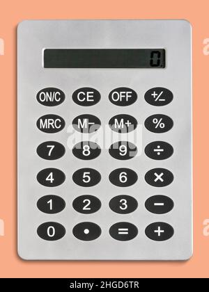 Top view of plain gray calculating machine with black buttons and various numbers placed on orange background in light room Stock Photo