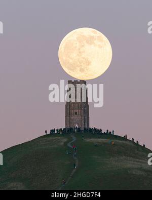January full wolf moon resting on St Michael's Tower on Glastonbury Tor Stock Photo