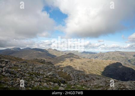 The Langdale Pikes with Helvellyn in the background viewed from the summit of Wetherlam near Coniston The Lake District Cumbria England Stock Photo