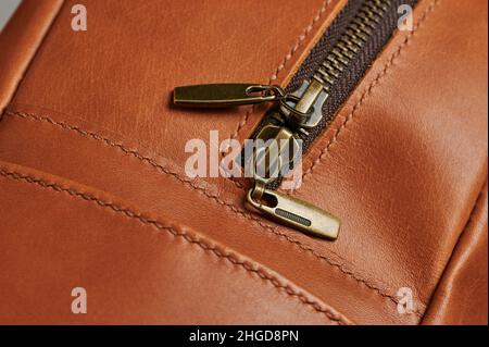 Metal shiny zipper on brown leather bag close up view Stock Photo
