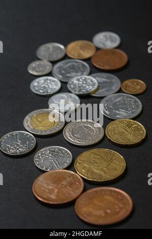 Coins of different countries. A scattering of coins on a black background Stock Photo