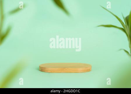 Close up photo of podium or platform made of bamboo and blurred bamboo leaves on green background. Natural and organic concept. Stock Photo