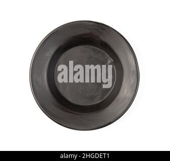 An old black soup plate with damage on a white background. Stylized tableware. Top view. Stock Photo