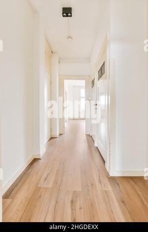 A long empty corridor in daylight with a wooden floor Stock Photo