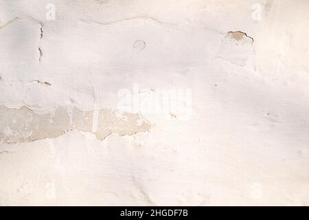 A concrete light wall with crumbling plaster. Natural background. Stock Photo
