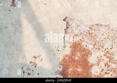 The old rusted surface is partially covered with crumbled whitewash with shadow. Natural background. Stock Photo