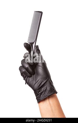 Hairdressers hand in black rubber glove holds a comb. Isolated on white background, close-up Stock Photo