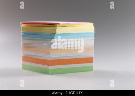 Uneven stack of sticky post it notes on grey surface, bunch of clean papers Stock Photo