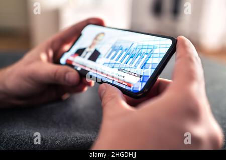 News in phone from tv broadcast stream. Man watching latest daily information from streaming live video with smartphone. Breaking headline. Stock Photo