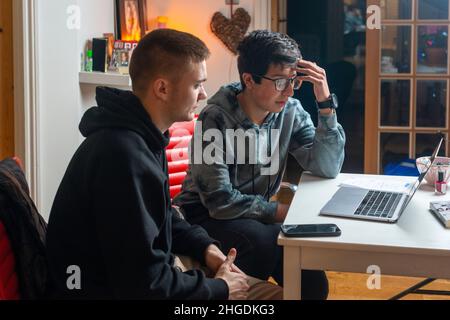 Students watch Videos on laptop, online lessons, online TV, UK Stock Photo