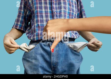 Female hand showing denial gesture against a man with empty pockets Stock Photo