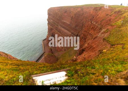Steep red sandstone cliffs in dense fog on the high seas sland of Heligoland, North Sea, Northern Germany, Central Europe Stock Photo
