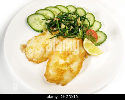 Low Carb Pan Fried Fish Fillets coated in Egg with Cucumber and Sea Weed Salad isolated on white Background Stock Photo