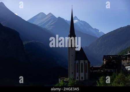 The parish church in Heiligenblut with the Grossglockner in the background in late evening sun Stock Photo