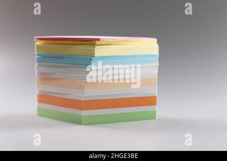 Uneven stack of sticky post it notes on grey surface, bunch of clean papers Stock Photo