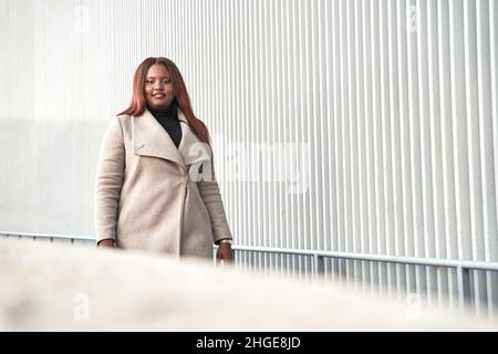 Smartly dressed business woman walking. Portrait of African American woman in suit. Stock Photo