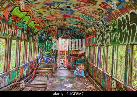 A close up inside of an abandoned train car with bright colored graffiti on the Delaware river Canal towpath in Lambertville NJ USA near New Hope Pa. Stock Photo