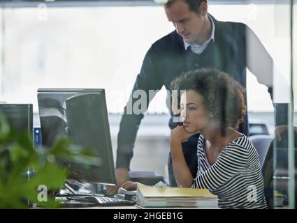Showing her the ropes. Cropped shot of two young designers working on a pc. Stock Photo