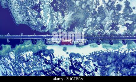 Elevated view of the trestle (friendship) trail in winter. The trail goes across the lake from one city to another. The water is frozen over with snow Stock Photo