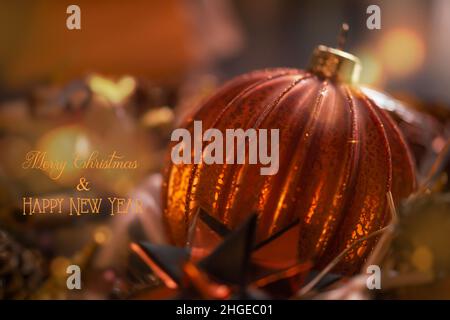 Close up of copper colored Christmas ball. Handmade crackled glass ball. English text: Merry christmas and happy new year. Stock Photo