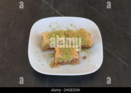 Baklava is a layered pastry dessert made of filo pastry, filled with chopped nuts, and sweetened with syrup or honey. Stock Photo