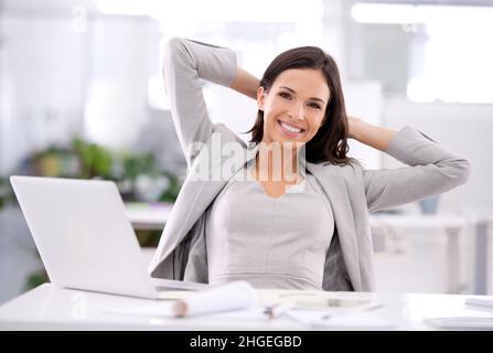 She's made it. Shot of an attractive businesswoman sitting at her desk in an office. Stock Photo