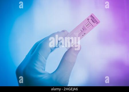 Closeup view of gloved hand with SARS-CoV-2 rapid antigen test nasal. Self test verifies positivity covid-19. Health, healthcare protection, contagion Stock Photo